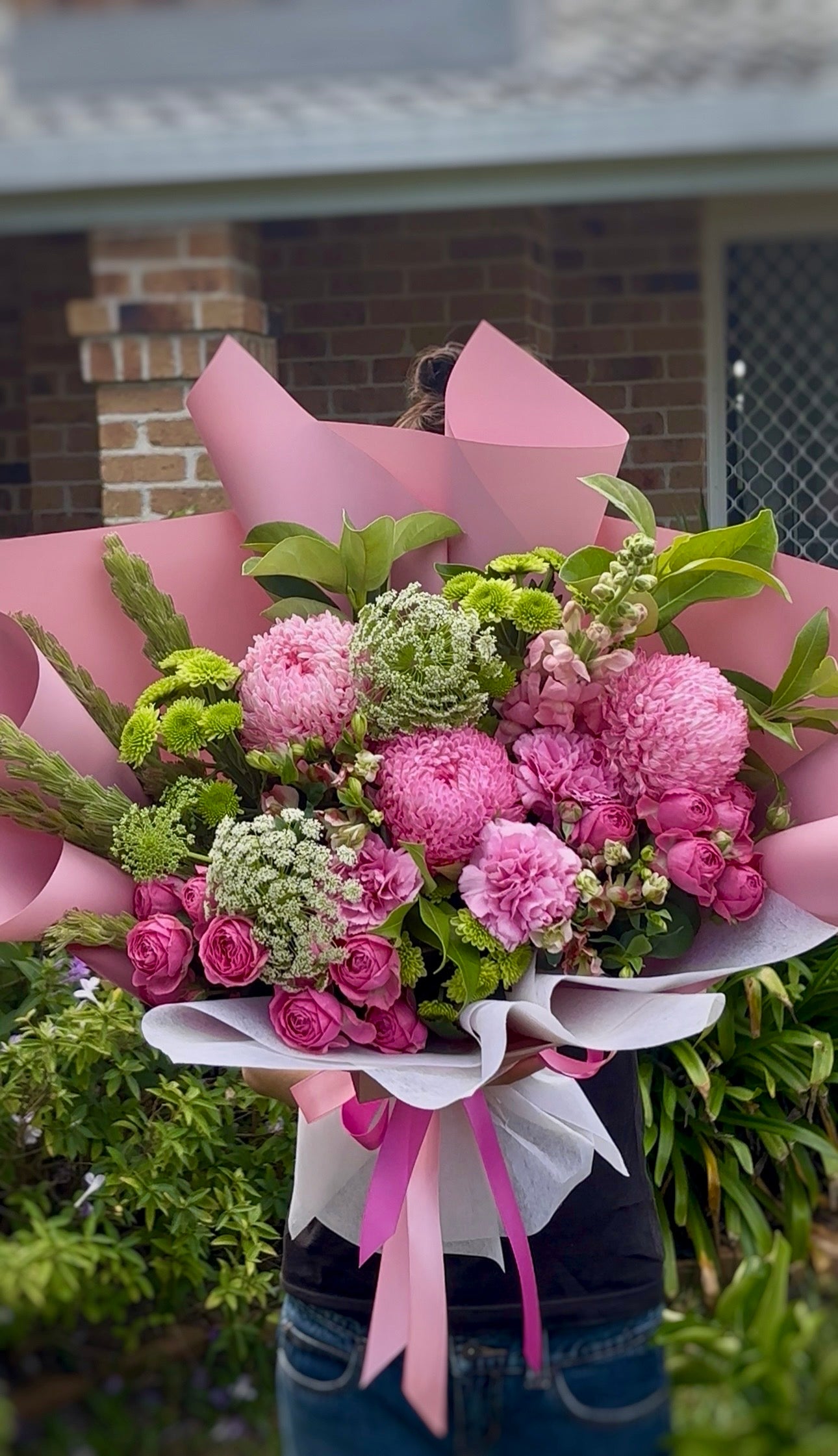 Bouquet of pink and green flowers wrapped in pink paper